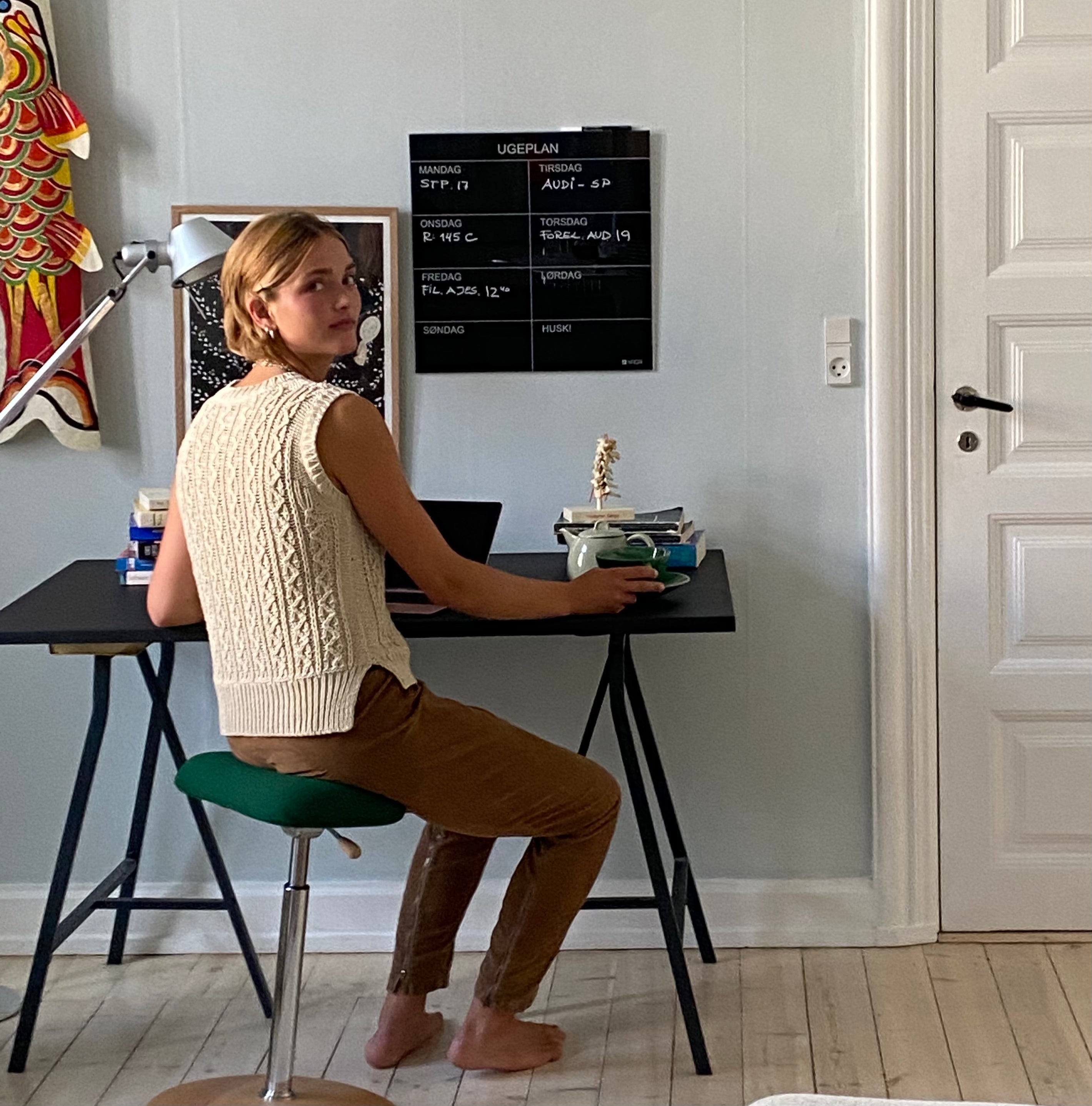 Ung kvinde sidder og studerer på en ReForm Disc, sædet er betrukket med mørkegrøn Hallingdal fra Kvadrat.